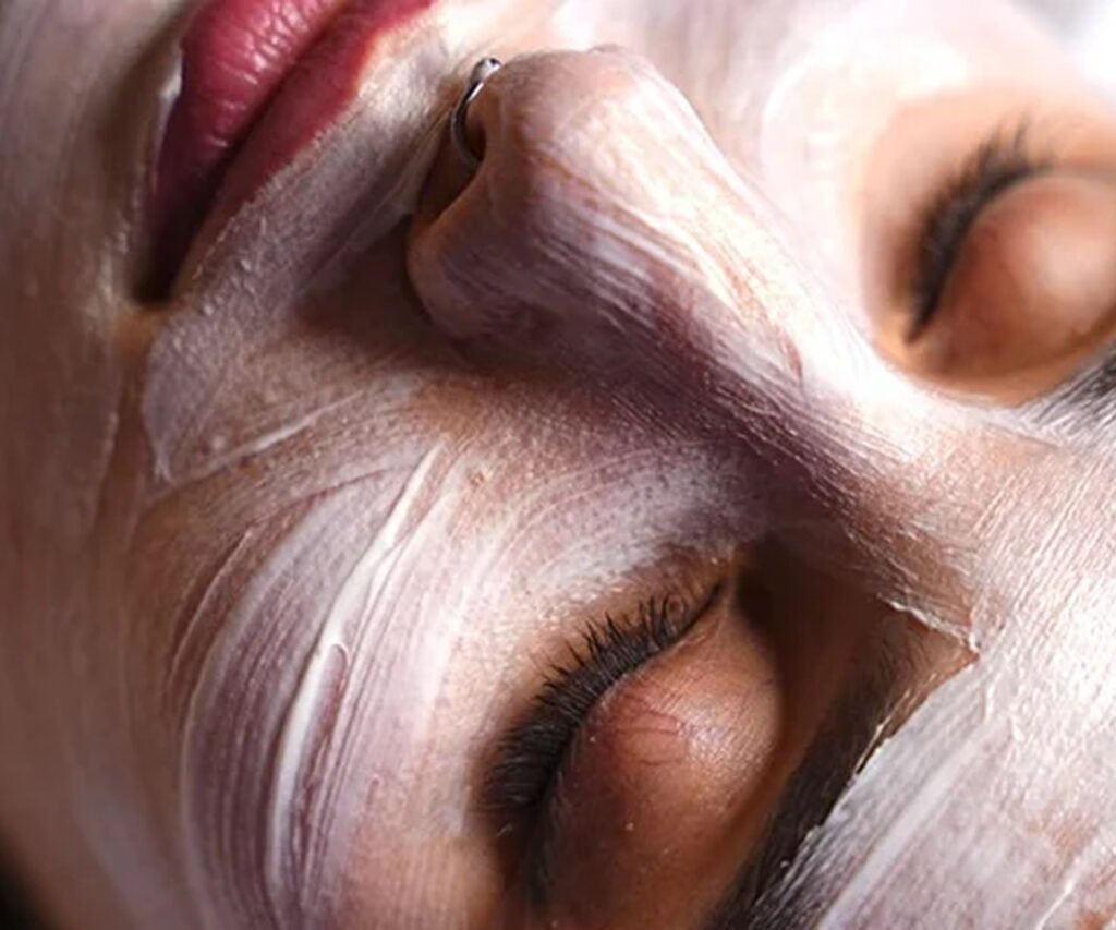 A close-up of a person relaxing with a white facial bleaching mask applied
